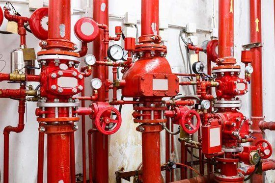 Red sprinkler riser assembly with grooved pipe, alarm valves and pressure gauges