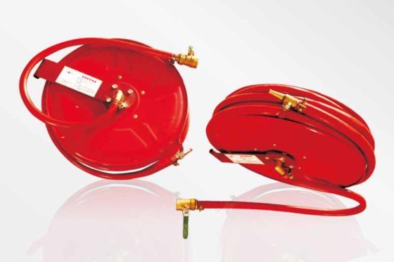 Two red fire hose reels with brass valves and nozzles